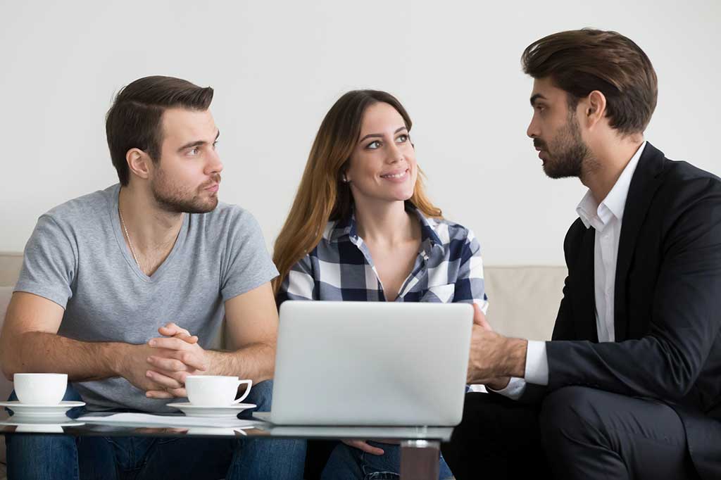 Couple sitting with an attorney working out a Prenuptial Agreement.